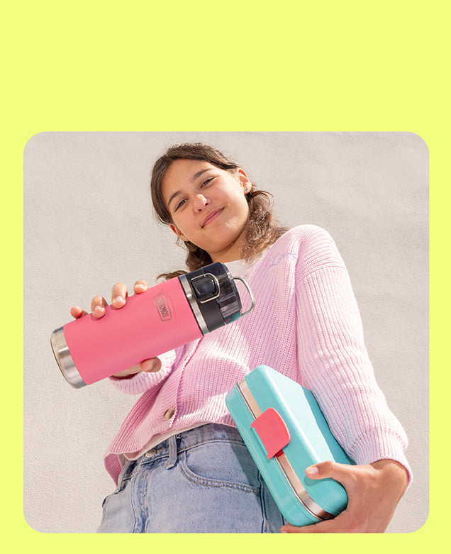 Girl holding Icon Kids water bottle and the Icon Kids Food Storage System
